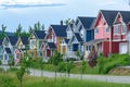 A vibrant row of houses with different colors stands along the side of a road, Suburban neighborhood with pastel colored houses, Royalty Free Stock Photo