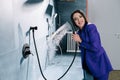 Vibrant saleswoman in a purple suit testing a showerhead, water running Royalty Free Stock Photo