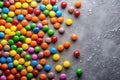 A vibrant scattering of colorful candy buttons on a textured gray surface, creating a cheerful and appetizing composition. Royalty Free Stock Photo
