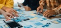 Collaborative design session with diverse hands working on mobile app prototypes and wireframe layouts on a large table Royalty Free Stock Photo