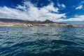 Vibrant scenery and deep-blue waters of the Tenerife west coastline as seen from a yacht. The dormant Teide volcano can be seen in