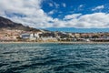 Vibrant scenery and deep-blue waters of the Tenerife west coastline as seen from a yacht. The dormant Teide volcano can be seen in