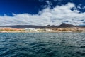 Vibrant scenery and deep-blue waters of the Tenerife west coastline as seen from a yacht. The dormant Teide volcano can be seen in