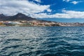 Vibrant scenery and deep-blue waters of the Tenerife west coastline as seen from a yacht. The dormant Teide volcano can be seen in