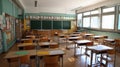 Vibrant empty elementary school classroom with desks, chairs, blackboard, and colorful wall decorations. Royalty Free Stock Photo