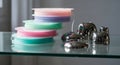 A vibrant stack of colorful thread spools arranged on a glass shelf with silver headphones and a blurred indoor background Royalty Free Stock Photo