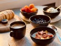 Vibrant still life of three bowls of food and a cup of coffee on a wooden table