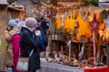 Vibrant street scene at night with people milling around decorated booths at Christmas.