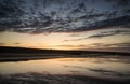 Vibrant sunrise landscape reflected in low tide water on beach Royalty Free Stock Photo