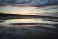 Vibrant sunrise landscape reflected in low tide water on beach Royalty Free Stock Photo