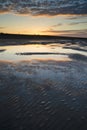 Vibrant sunrise landscape reflected in low tide water on beach Royalty Free Stock Photo