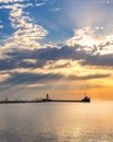 Vibrant sunrise with sun rays over a long freighter ship pier. Port Credit