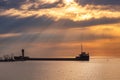 Vibrant sunrise with sun rays over a long freighter ship pier. Port Credit Mississauga