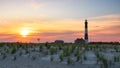 Vibrant sunset behind a tall stone lighthouse. Fire Island National Seashore, NY Royalty Free Stock Photo