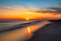 Vibrant sunset over the ocean as the sun dips below the horizon creating light rays and reflections in the surf