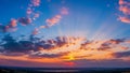 Vibrant Sunset Sky with Sun Rays and Clouds Over Horizon Royalty Free Stock Photo