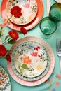 Vibrant table setting featuring plates and cups decorated with colorful flowers and silver cutlery