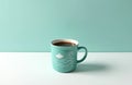Vibrant teal ceramic mug with dark coffee sits on crisp white surface, against light blue wall. Mug features charming, simple Royalty Free Stock Photo