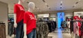 A Vibrant textile store in Mumbai during sale time, female mannequins flaunting red SALE tees