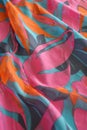 Vibrant tropical pattern on draped fabric featuring bold pink, turquoise, and orange tones. A dynamic textile background, ideal Royalty Free Stock Photo