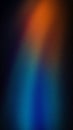 A vibrant vertical gradient with deep blue, orange, and red hues, enhanced by a grainy texture. Perfect for bold wallpapers, Royalty Free Stock Photo