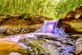 Vibrant waterfall in forest with rocky cliffs