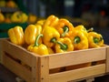 Vibrant yellow bell peppers arranged in a wooden crate, showcased against a blurred market background, symbolizing