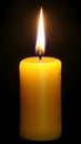 Vibrant yellow candle glowing in darkness Royalty Free Stock Photo