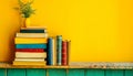 Vibrant Yellow Wall with Colorful Books on Wooden Shelf and Decorative Vase with Green Plant Royalty Free Stock Photo