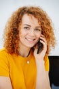 Vibrant young woman with curly red hair talking on the phone Royalty Free Stock Photo