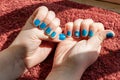 Vibrantly painted blue fingernails with a flower Royalty Free Stock Photo