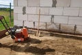 Vibrating plate in use, the worker with the help of a vibrating plate compacts the sand, building a house Royalty Free Stock Photo