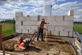 Vibrating plate in use, the worker with the help of a vibrating plate compacts the sand, building a house Royalty Free Stock Photo