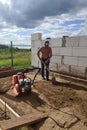 Vibrating plate in use, the worker with the help of a vibrating plate compacts the sand, building a house Royalty Free Stock Photo