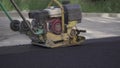 Vibratory asphalt paving machine HONDA on the sidewalk filmed close-up.Road works,pavement repair,hard work.Video clip