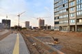 Vibratory plate compactor for compact the gravel. Laying paving slabs and borders at construction site. Tower cranes in action Royalty Free Stock Photo