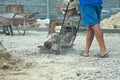 Vibratory plate construction site. Construction workers installing and arranging precast concrete pavers stone for road Royalty Free Stock Photo