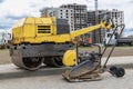 Vibratory rammer with vibrating plate on a construction site. Manual roller. Compaction of the soil before laying paving slabs. Royalty Free Stock Photo