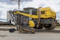 Vibratory rammer with vibrating plate on a construction site. Manual roller. Compaction of the soil before laying paving slabs.