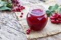 Viburnum fruit jam in a glass jar on a wooden table near the ripe red viburnum berries. Source of natural vitamins. Used in folk Royalty Free Stock Photo