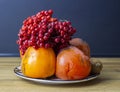 viburnum, persimmon and kiwi are on a plate