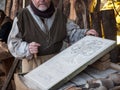 Stonemason carves and shapes the stone with a wooden hammer and chisel Royalty Free Stock Photo