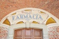 Arcade in red bricks around Sanctuary of Vicoforte church, ancient pharmacy sign in Piedmont, Italy