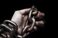 Victim, slave, prosoner male hands tied by big metal chain by hi Royalty Free Stock Photo