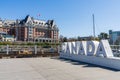 Canada Sign, Victoria Inner Harbour. Historical buildings in the background over blue sky.