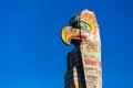 Totem pole located in front of the Royal BC Museum over blue sky