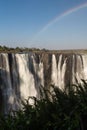Victoria Falls in October with rainbow crossing Royalty Free Stock Photo