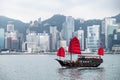 Iconic red junk boat cruising around Hong Kong skyline