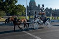 Victoria, Vancouver Island, BC, Canada August, 26th, 2018: A horse drawn carriage with tourists passes the parliament building in