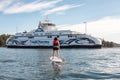 Adventurous woman paddle boarding near BC Ferries Boat in Swartz Bay